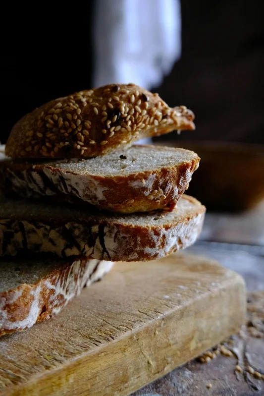 A detailed close-up of rustic, freshly baked artisan bread loaf with flour dusting.